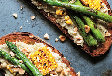 Spargel-Mais-Bruschetta mit Artischocke, Zitronenpesto und Haselnüssen
